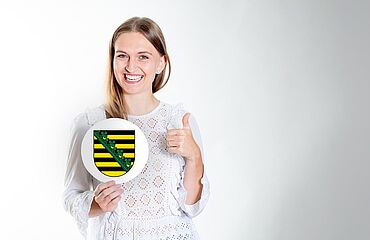 Beihilfe Sachsen: Beamtin mit Landeswappen von Sachsen